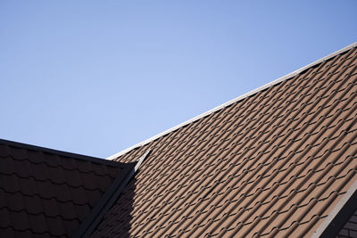 Low angle view of building roof against clear sky