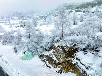 Large ice stalactites hang from the high cliff