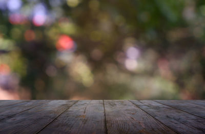 Empty wooden table in front of blurred garden and nature light background. montage product display