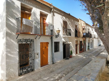 Houses by street in town against sky