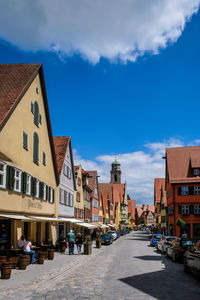 Street amidst buildings in town against sky
