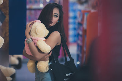 Young woman holding stuffed toy