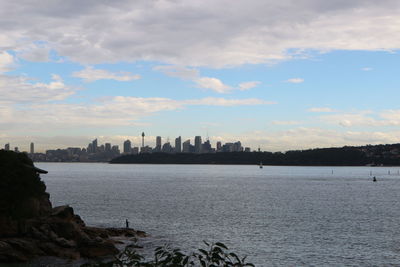 Scenic view of sea by buildings against sky