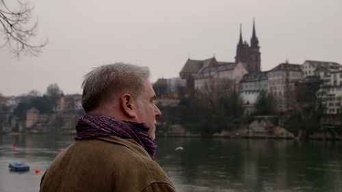 Portrait of man in city against sky during winter