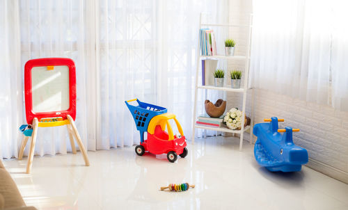 Toys and decors on field floor by curtains at home