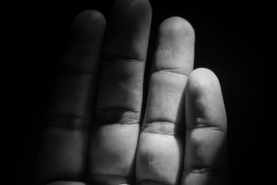 Close-up of human hand against black background