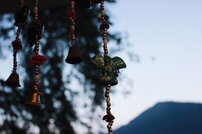 Low angle view of wind chime hanging against sky