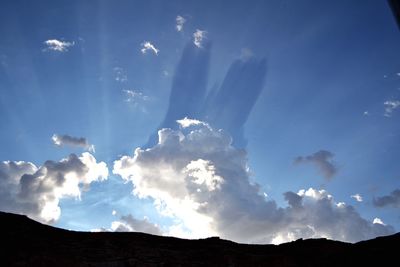 Low angle view of mountain against cloudy sky