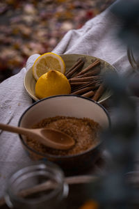 Table setting of sliced lemons, cinnamon sticks, brown sugar and honey