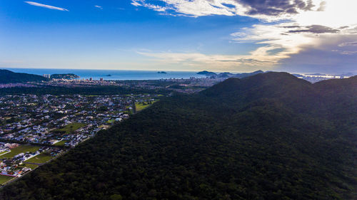 Aerial view of town by sea against sky