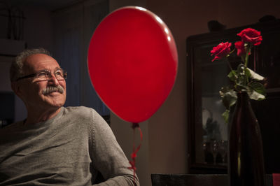 Portrait of man with red balloons