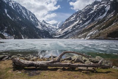 Scenic view of lake by snowcapped mountains against sky