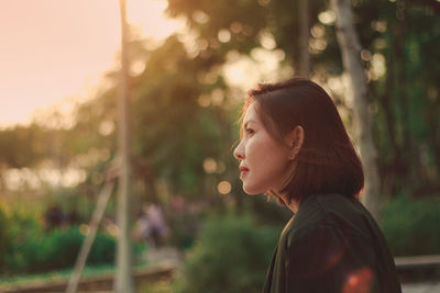 Portrait of young woman looking away outdoors