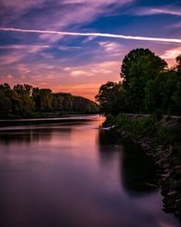 Scenic view of river against sky at sunset