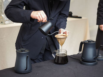 Midsection of man working with coffee cup