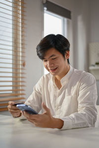 Portrait of young woman using laptop at home