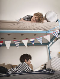 Brothers lying on bunkbed at home