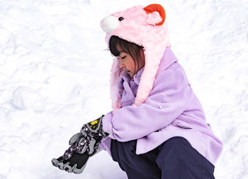 Midsection of woman with pink umbrella on snow field