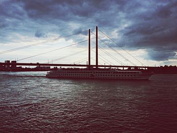 Suspension bridge against cloudy sky