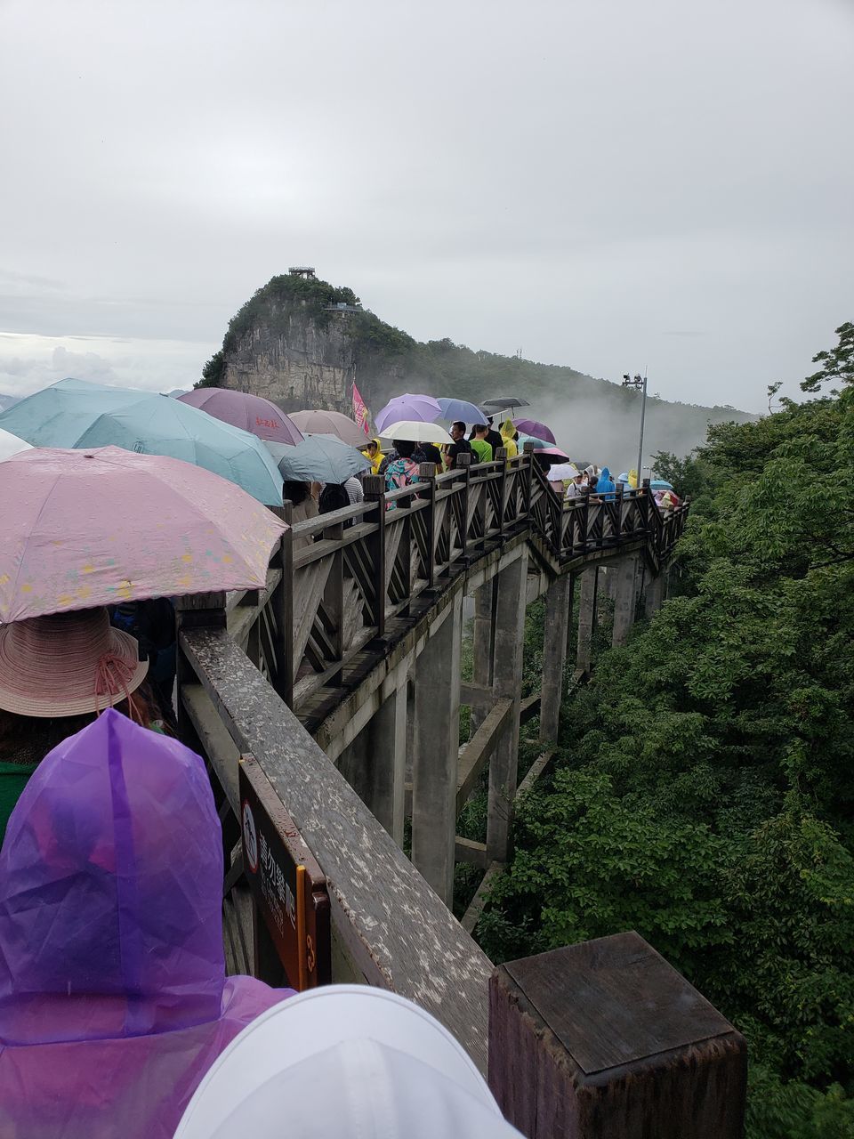 REAR VIEW OF PEOPLE WALKING ON RAINY DAY