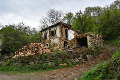 Abandoned house on field against sky