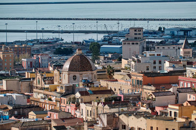 High angle view of townscape by sea against sky