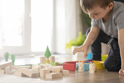 Portrait of boy playing with toy blocks at home