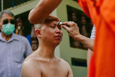 Close-up of shirtless man holding hands