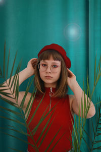 Portrait of teenage girl standing against wall