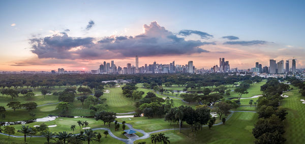 Panoramic view of city buildings against sky during sunset