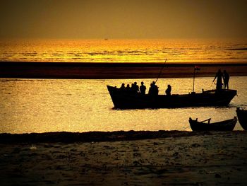 People on shore at sunset