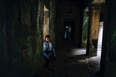 Woman sitting in abandoned building