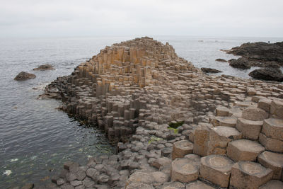 Stone wall by sea against sky