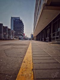 Surface level of footpath by buildings against sky