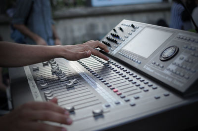 Cropped image of hand operating sound mixer