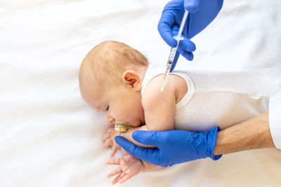 Doctor giving vaccination to baby girl at clinic