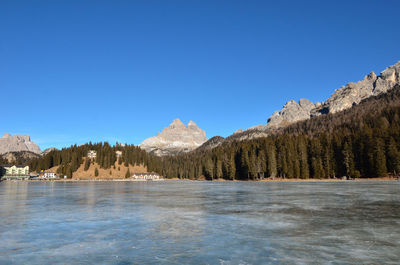 Scenic view of lake against clear blue sky