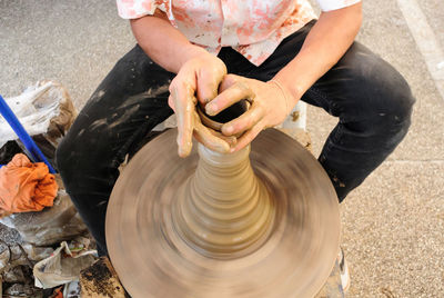 Midsection of potter making pot