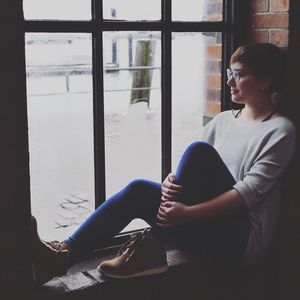 Woman sitting in window sill