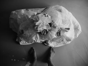 Low section of man standing by fabric on floor