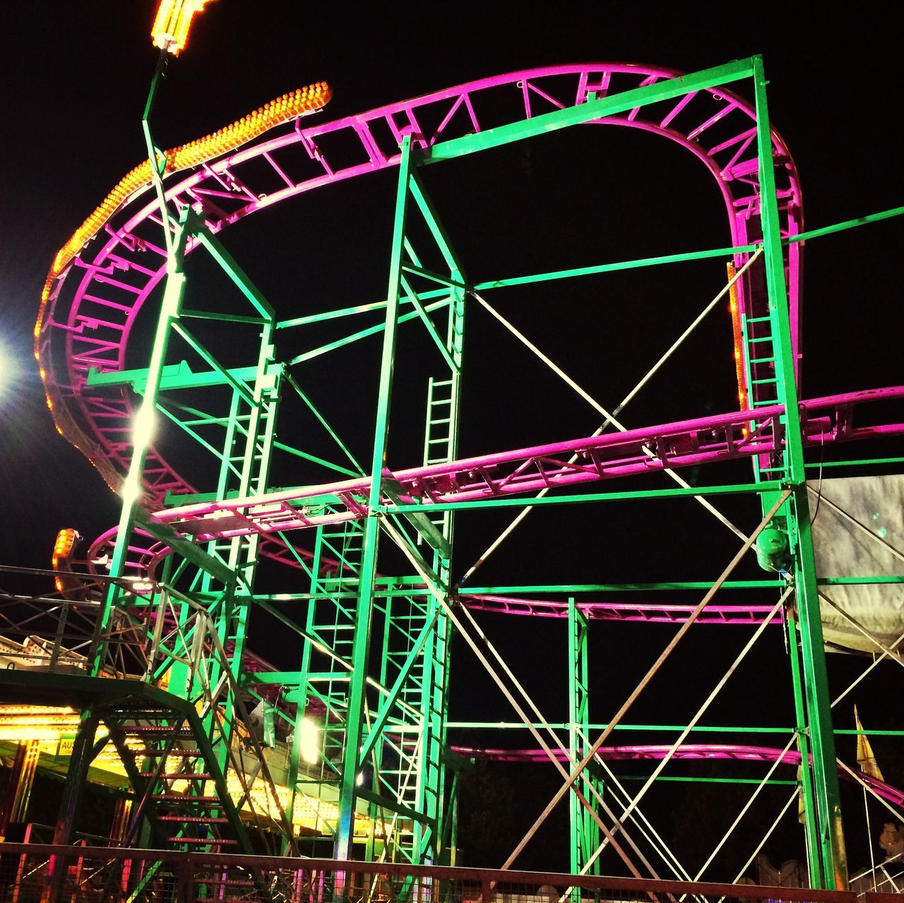 amusement park, amusement park ride, arts culture and entertainment, ferris wheel, low angle view, night, illuminated, built structure, sky, metal, circle, architecture, fun, blue, enjoyment, large, outdoors, big wheel, multi colored, traveling carnival