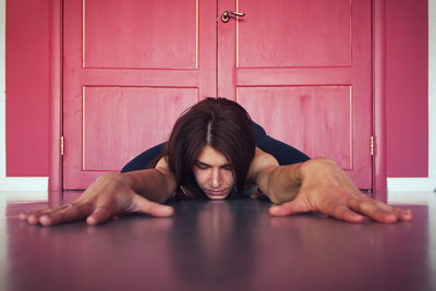 Depressed young woman lying down on floor