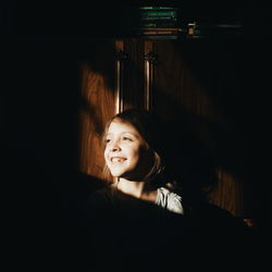Sunlight falling on smiling girl standing at home