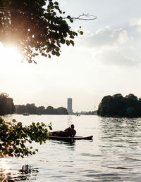 Rear view of man lying on paddling board