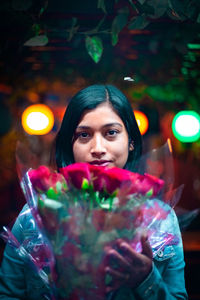 Portrait of young woman holding camera