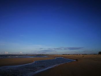 Scenic view of beach against clear blue sky