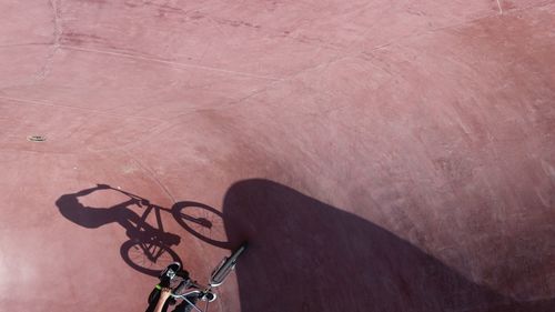 Shadow of person riding bicycle on footpath