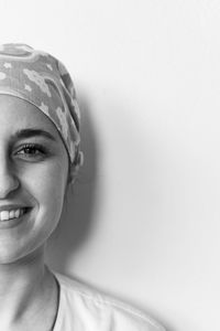 Close-up portrait of a smiling young woman against white background