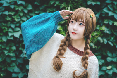 Woman standing against hedge