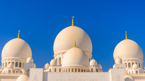 Low angle view of mosque against clear sky during sunny day